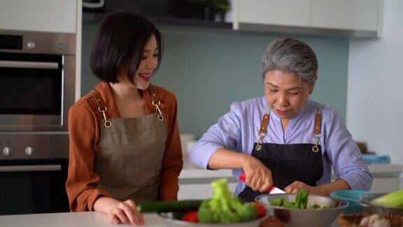 亚洲母亲示范如何切蔬菜给女儿