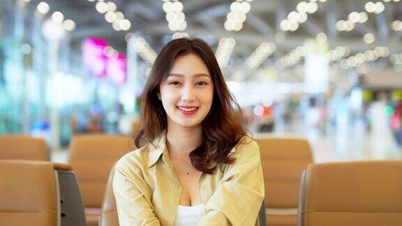 亚洲妇女在机场等待离开假期假期亚洲女乘客拿出口罩防护看着镜头