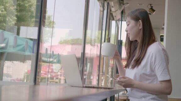 年轻女子在咖啡馆用智能手机