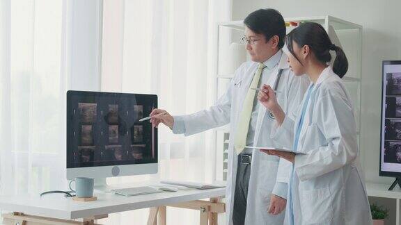 医疗队男女医生在医院电脑上检查病人的x线图像讨论结果
