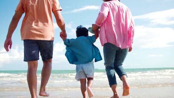 快乐的亚洲家庭在沙滩上奔跑