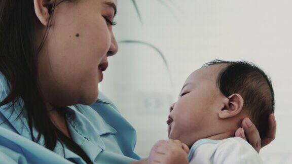 年轻的亚洲母亲和她刚出生的儿子说话