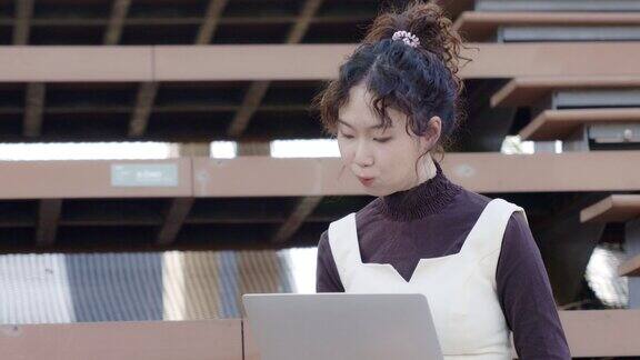 亚洲女商人坐着工作用笔记本电脑联系在线会议