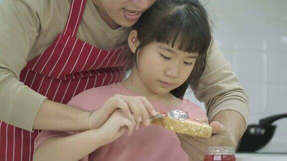 亚洲父亲和快乐的小女儿有乐趣而烹饪一起在厨房在家里