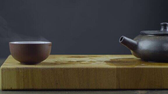 手工制作的宜兴砂茶壶用木板上的碗盛热茶4k4k的视频缓慢的运动24帧秒