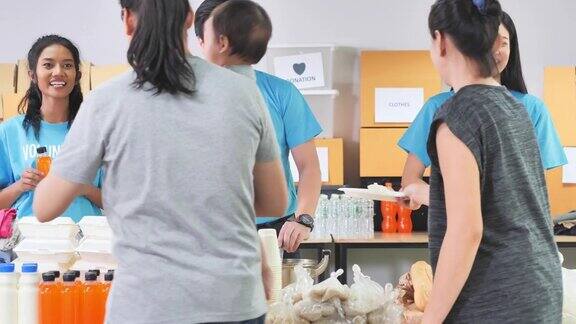 团体混合人种志愿者为亚洲人准备免费送餐友谊团队成功志愿领导人慈善理念
