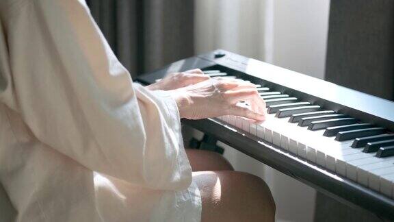 在阳光的照射下女音乐家在家中弹奏钢琴