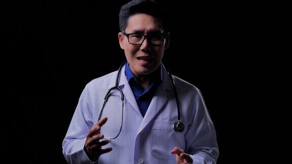 有经验的亚洲男性医生对着摄像机说话男性医生在黑色背景的视频会议上进行视频对话工作的骄傲概念
