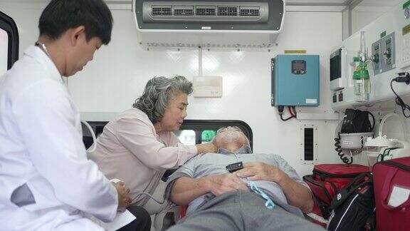 医生在救护车上检查病人和病人的妻子一起