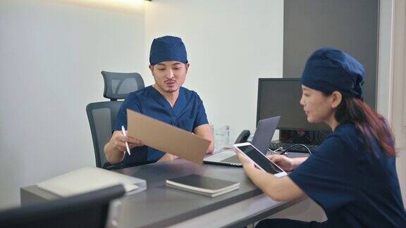 2名亚洲华人医生在医生办公室开会讨论