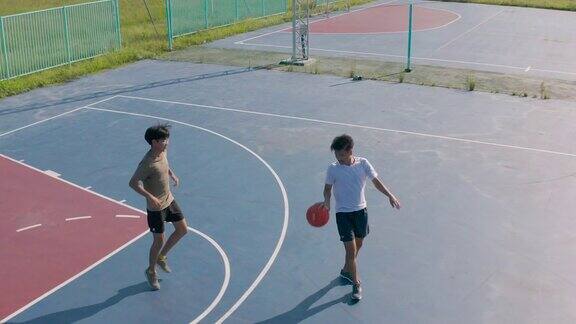 两个年轻的朋友在户外打篮球