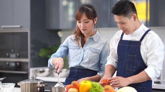 亚洲年轻夫妇在自家厨房做饭