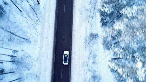 汽车在冬天的路上行驶冬天的路上树木和灌木丛被雪覆盖着