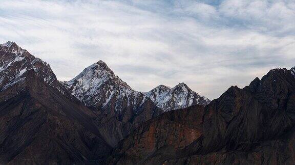 在巴基斯坦北部斯卡都的喀喇昆仑山脉寒冷的沙漠周围有雪帽山移动的云和灰尘吹过沙丘