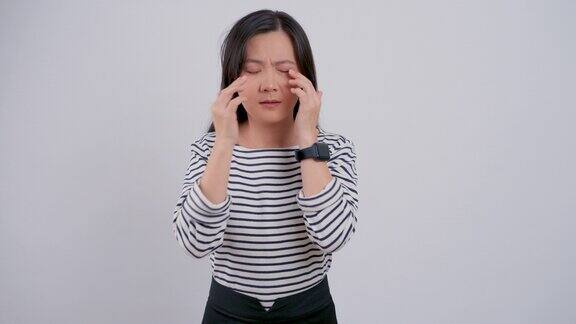 一名亚洲妇女孤立地站在白色背景上眼睛疼痛