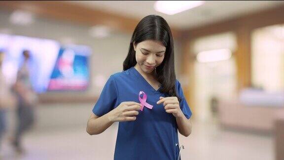 医生护士站在医院带着粉红色的丝带微笑着