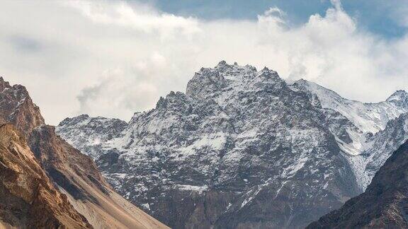 在巴基斯坦罕萨山谷地区的帕苏山谷喀喇昆仑山脉的秋天雪山的壮丽景色的延时移动云日出