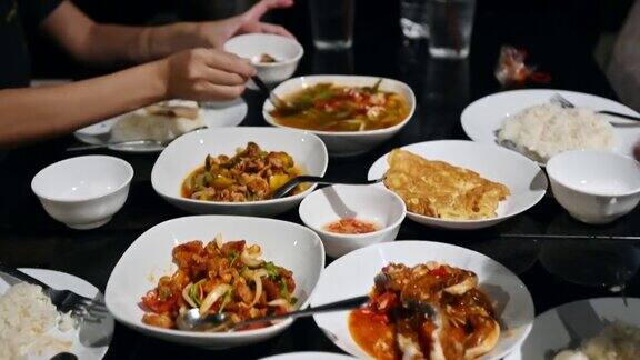 一群朋友在餐桌上吃各种泰国菜