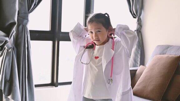 可爱的亚洲小女孩穿着医疗制服在家里扮演医生