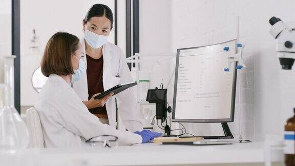 研究、新冠病毒和妇女在实验室的电脑上讨论科学、医疗保健规划和创新战略制药和科学家团队在网上对口罩的结果进行分析