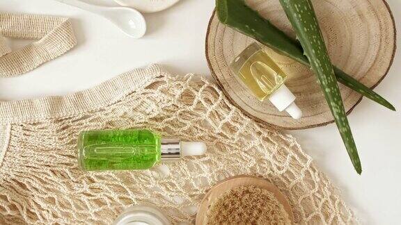 绿色芦荟白色背景的环保产品凝胶液体胶原蛋白精华精油盐按摩刷天然有机护肤生态化妆品平的