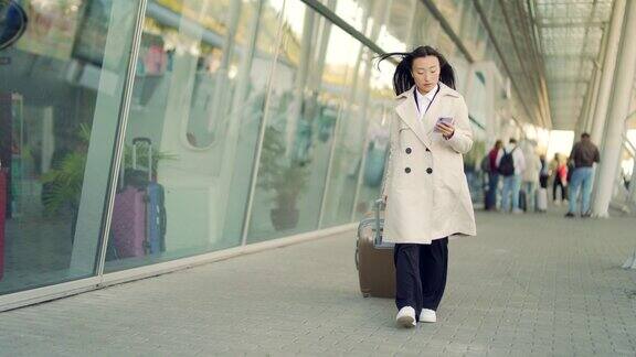 亚洲女旅游商人走手提箱从航站楼机场背景现代城市火车站城市街道