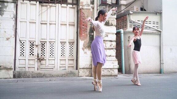 侧视图:年轻的女芭蕾舞老师在当地的街道和旧建筑作为教室教学生带领白人青少年芭蕾舞者练习芭蕾舞概念活泼的年轻妇女和孩子在周末的活动
