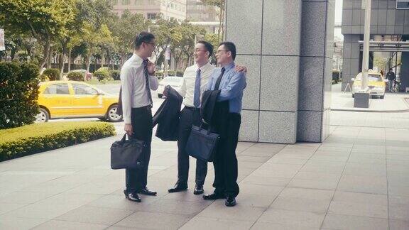 三个快乐的亚洲商人在街上走着笑着