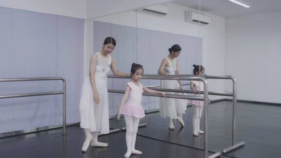 芭蕾舞学校的老师帮助年轻的芭蕾舞演员表演不同的舞蹈练习他们在芭蕾舞课上排练老师和孩子们交流