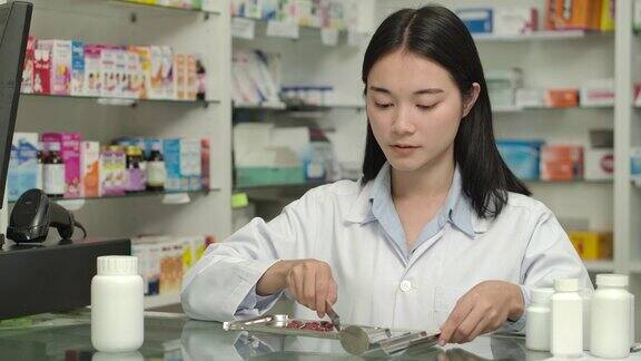年轻的亚洲女药剂师数处方药丸药物