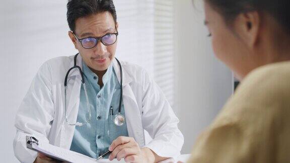 成熟的亚洲男性医生在健康门诊咨询女性病人时的医疗结果