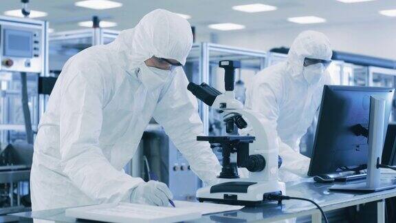 在实验室科学家做研究使用显微镜和输入数据