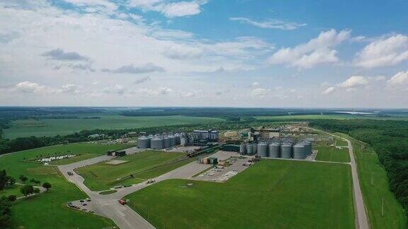 在自然界中的制造工厂粮食储罐绿色田野间的大型金属筒仓鸟瞰图