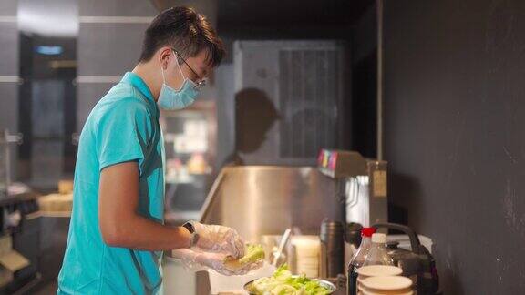 一名中国快餐工人在娱乐大楼的小卖部准备热狗三明治