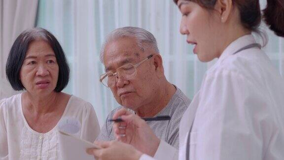 60-69岁的亚洲老年夫妇在医院检查和医疗咨询时与亚洲年轻女护士医生交谈老年夫妇倾听照顾者给予的支持
