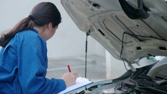 亚洲女机械师检查汽车竖起大拇指微笑着