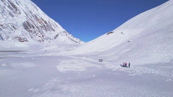 航拍镜头揭示了一群徒步旅行者在喜马拉雅山步道到蒂利哥湖的目的地安纳普尔纳环行徒步旅行路线和徒步旅行者在尼泊尔山脉