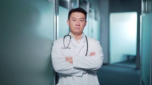 肖像自信的亚洲医生男子严肃地看着镜头背景是一个现代化的医院医疗诊所