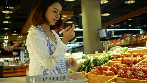 孕妇在超市购物和使用手机