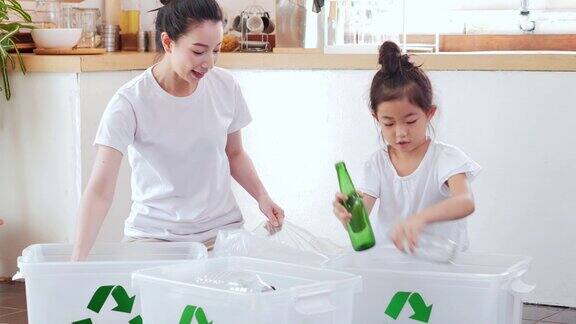 快乐的亚洲母亲教小女儿可持续发展如何在家里回收家庭垃圾教学习可重复使用的产品和零废物家庭教育日常循环利用