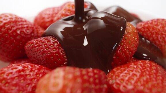 特写宏新鲜草莓覆盖着融化的液体巧克力融化的巧克力或棕色焦糖流浇在多汁的红色浆果糖果美味的甜点烹饪手工糖果