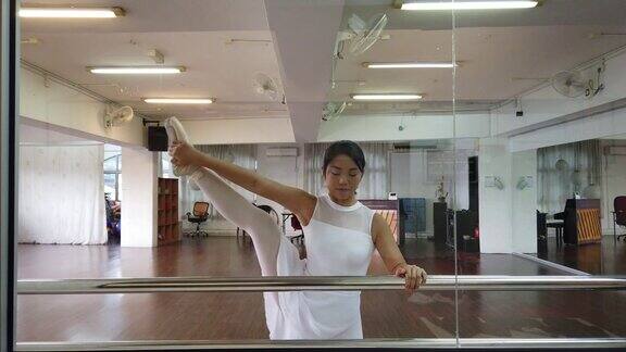 一位亚洲中国女芭蕾舞演员在舞蹈工作室练习准备自己