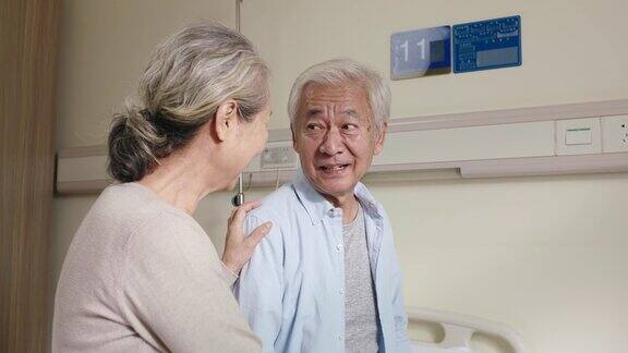 年长的亚洲妇女在医院病房探望丈夫