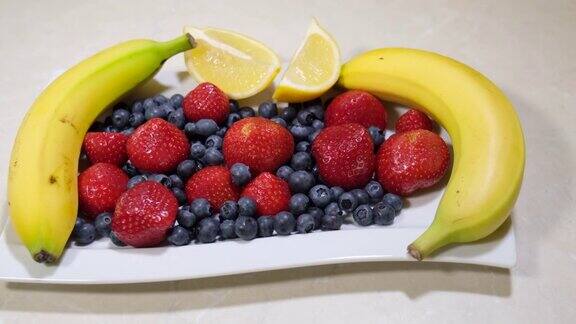 水果沙拉什锦水果新鲜草莓、蓝莓、香蕉、柠檬热带健康的混合维生素