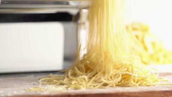 一名男子将面粉洒在刚做的意大利面上烹饪时厨师面包师把意大利面堆成一堆制作面食的过程近距离