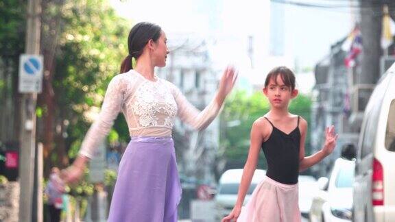 在一个阳光明媚的日子里年轻的女芭蕾舞老师教学生白种青少年芭蕾舞者在曼谷的一间教室里练习芭蕾舞活跃的年轻妇女和孩子周末活动和当地地标