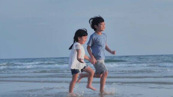 幸福男孩女孩牵手海边沙滩快乐地奔跑
