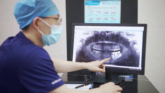 牙科医生手持防护口罩仔细检查牙科x光片