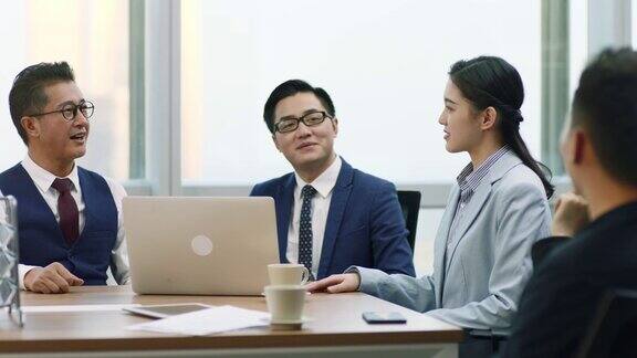 年轻的亚洲女商人和商人在团队会议上握手