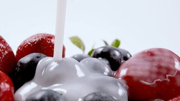 将酸奶或牛奶倒在有机新鲜蓝莓和草莓上奶油浆果有机素食特写4k分辨率